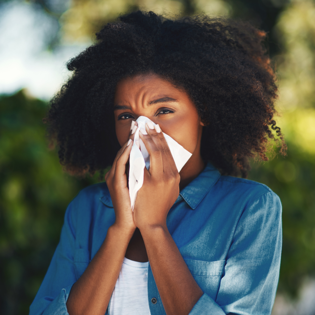 Lady holding tissues blowing her nose close up.