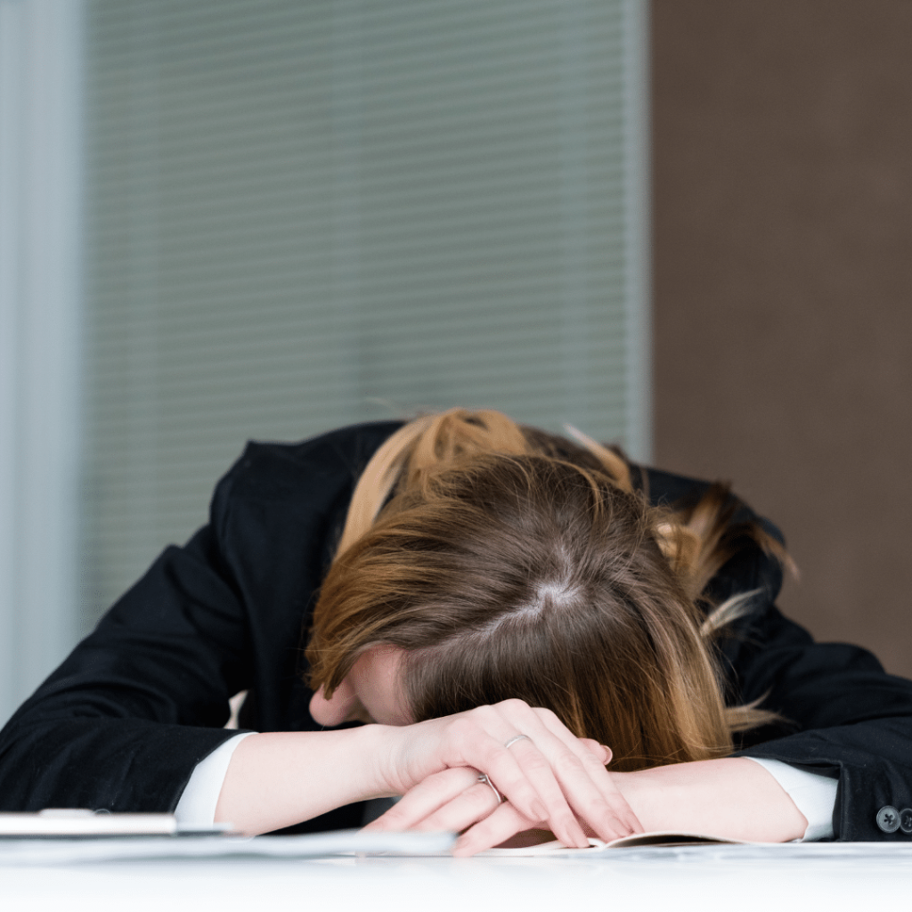 Office lady sitting with arms crossed and head laying down.