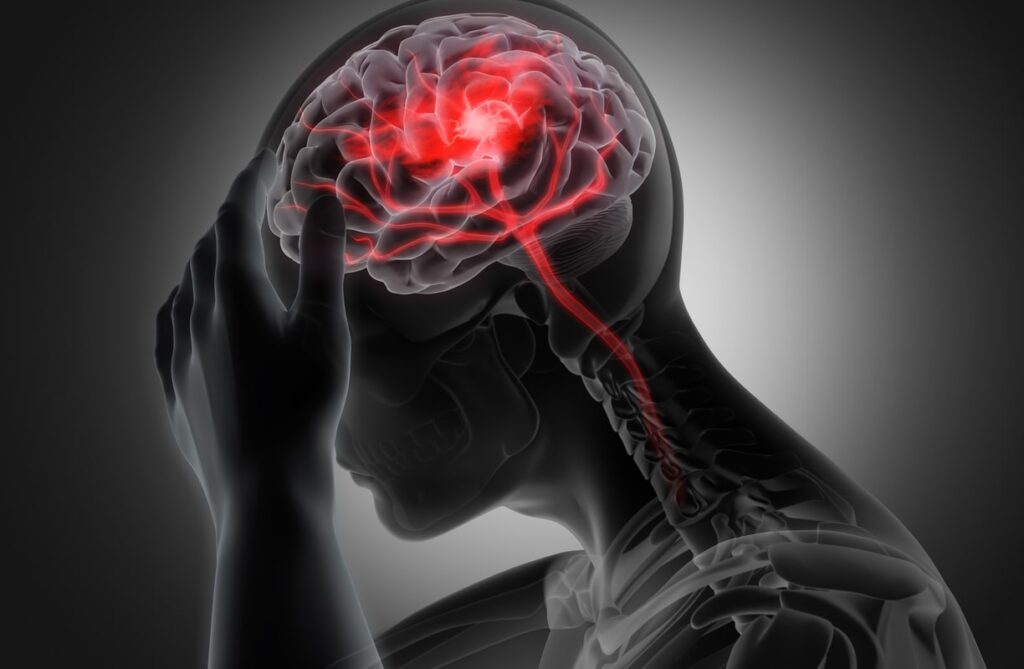 Illustration of a person holding their head in pain, showing a highlighted brain and spinal cord to represent neurological issues or severe headache.