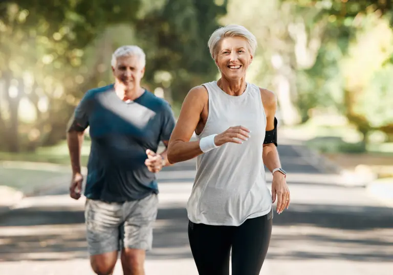 Active older couple walking outdoors pain-free after treatment.